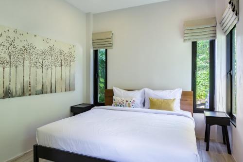 Schlafzimmer mit einem großen weißen Bett und Fenstern in der Unterkunft Villa primor Chaloklum Koh phangan in Chaloklum