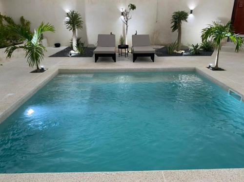 a large pool with blue water in a yard at Villa Le Petit Paradis Saly Boutique Hotel in Ngaparou