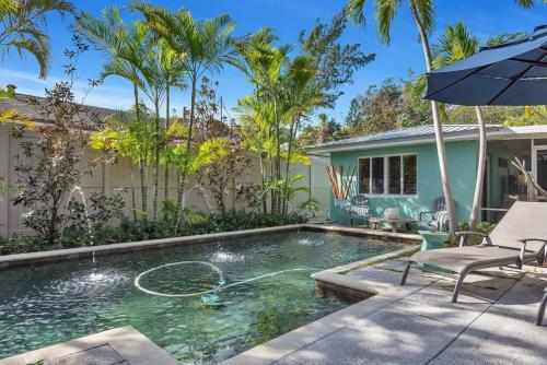 沃思湖Charming Studio w Pool One Mile to Beach Pets Welcome的带遮阳伞的游泳池和房子