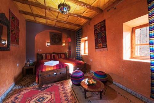 1 dormitorio con 1 cama y 1 mesa en una habitación en Kasbah Imlil, en Imlil