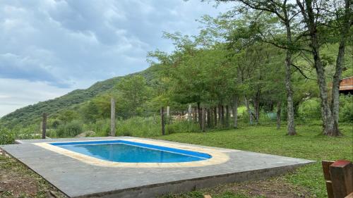 una piscina en un patio con una montaña en ALQUILER CABAÑA EN SAN JAVIER- TUCUMÁN in 