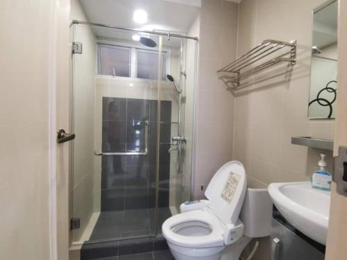 a bathroom with a shower and a toilet and a sink at Ocean Palms in Melaka