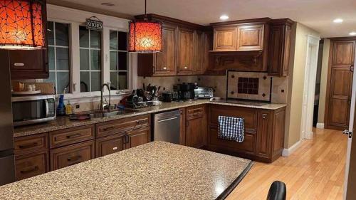 a kitchen with wooden cabinets and stainless steel appliances at #17 ROOM IN THE HOUSE Peerless Design Room with Private Bathroom! in Waltham