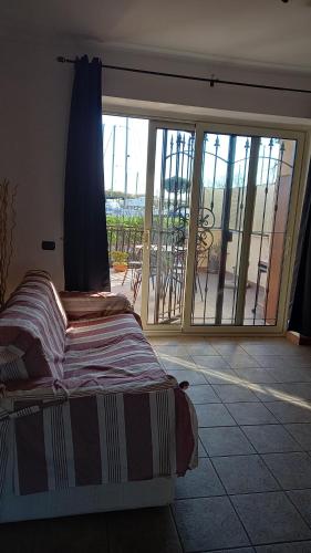 a bedroom with a bed and a view of a balcony at A Santy's House 1piano-no lift-raggiungibile a piedi aeroporto-fermata bus fiera di roma a 3 minuti-NO ANIMALI bed FOR A FEE A PAGAMENTO in Fiumicino