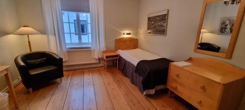 een slaapkamer met een bed, een stoel en een bureau bij Gysinge Herrgård in Österfärnebo