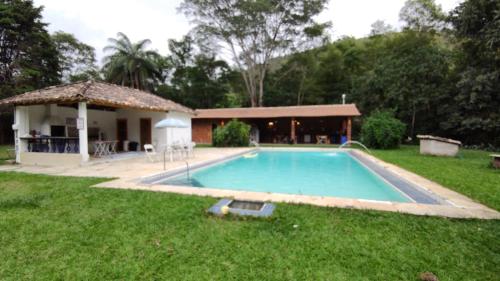 a swimming pool in the yard of a house at Pouso Donana Cama e Café in Itaipava