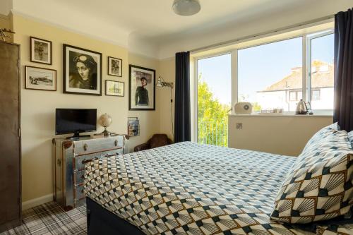 a bedroom with a bed and a large window at Twentieth Century B&B in Birchington