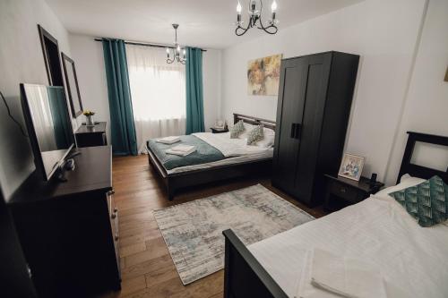 a living room with two beds and a tv at Pensiunea Magnesia (4 margarete****) in Sânâteşti