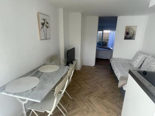 Habitación pequeña con mesa y sofá en Appart cosy avec terrasse en Mons-en-Baroeul