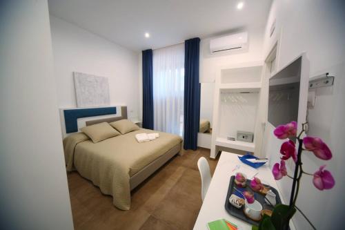 een kleine slaapkamer met een bed en een tafel met een sidx sidx bij Essence in Barletta