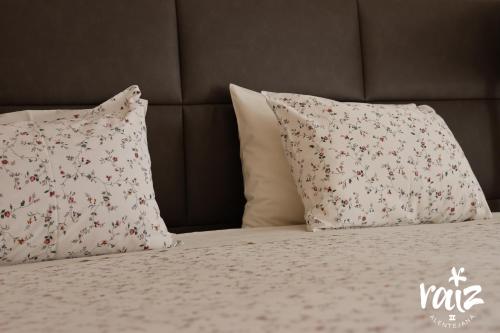 a bed with two pillows on it with a bedspread with flowers at Raiz Alentejana II in Reguengos de Monsaraz
