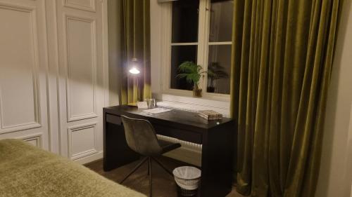een bureau in een kamer met een raam en een stoel bij Gysinge Herrgård in Österfärnebo