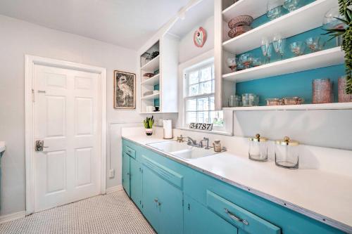 - une salle de bains bleue et blanche avec un lavabo et des armoires bleues dans l'établissement Downtown Winter Garden Cottage about 12 Mi to Disney!, à Orlando