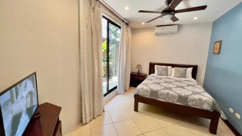 a bedroom with a bed and a flat screen tv at Monte Carlo Luxury Condominiums in Jacó