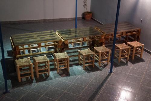 アガディールにあるBayti surf hostelの木製テーブル、椅子、テーブル、椅子が備わります。