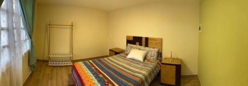 ein Schlafzimmer mit einem Bett mit einer bunten Bettdecke in der Unterkunft Katalina's Guest House Arequipa in Arequipa