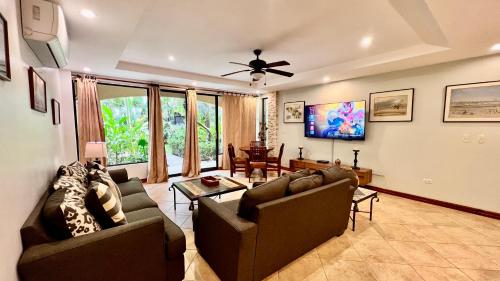 a living room with two couches and a table at Monte Carlo Luxury Condominiums in Jacó