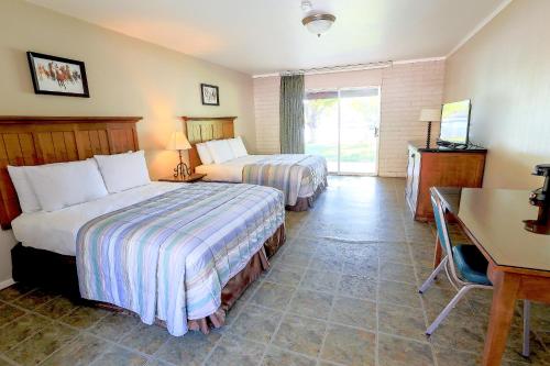 um quarto de hotel com duas camas e uma secretária e uma secretária em Roosevelt Resort Park em Roosevelt