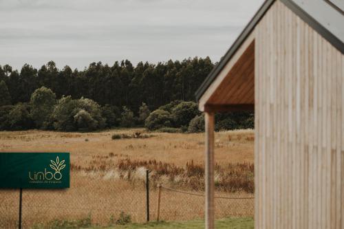 a sign on the side of a building next to a field at Limbo Cabañas de Malpica in Malpica