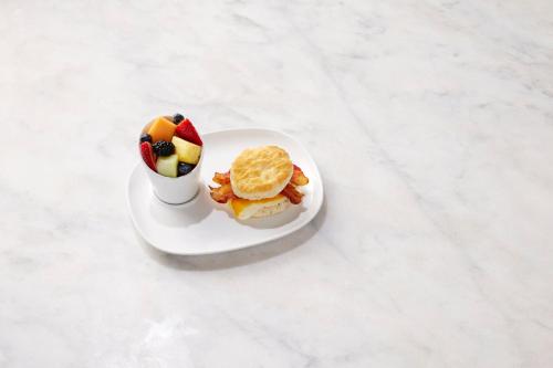 a plate of food with a sandwich and a cup of fruit at EVEN Hotel Rockville - Washington, DC Area by IHG in Rockville