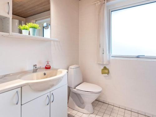 a bathroom with a toilet and a sink and a window at Holiday home Blåvand CCCXV in Blåvand