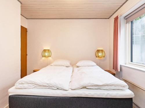 a bed in a room with two lamps and a window at Holiday home Blåvand CCCXV in Blåvand