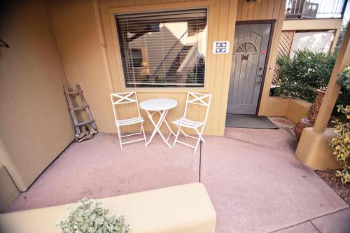 two chairs and a table in front of a house at The Inn at Thunder Mountain in Sedona