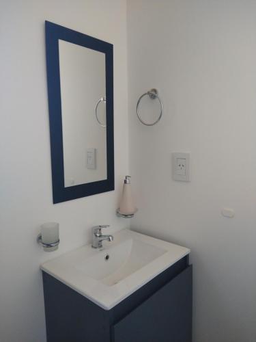a bathroom with a white sink and a mirror at Casa Cajita in Rancul