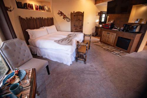 a bedroom with a bed and a chair and a television at The Inn at Thunder Mountain in Sedona