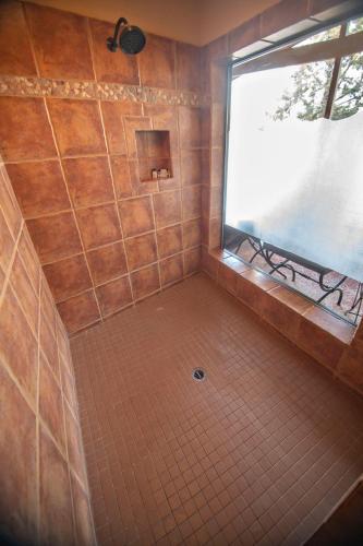 a shower with a window and a tiled floor at The Inn at Thunder Mountain in Sedona