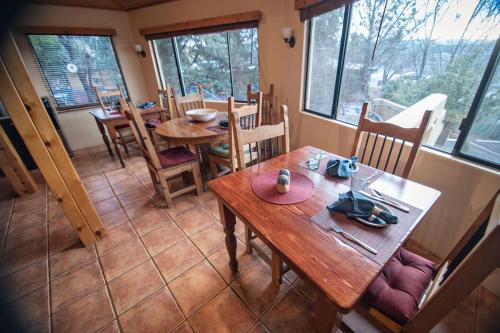 a dining room with tables and chairs and windows at The Inn at Thunder Mountain in Sedona