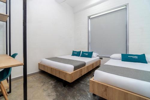 Duas camas num quarto com uma janela em Ayenda Living Box em Cali