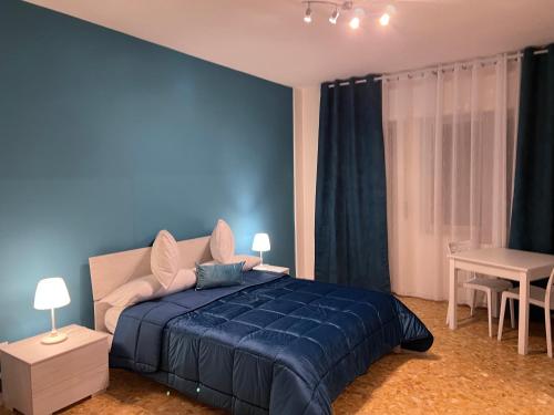 um quarto azul com uma cama e uma mesa em Residenze Unità d'Italia em Bari