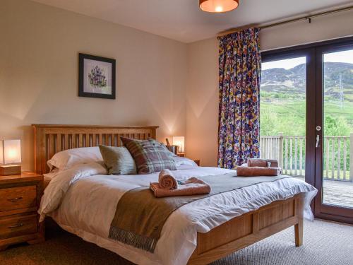 a bedroom with a large bed with a window at Glengoulandie Lodge in White Bridge