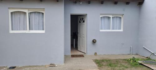 Casa blanca con puerta y ventanas blancas en La casita en El Calafate