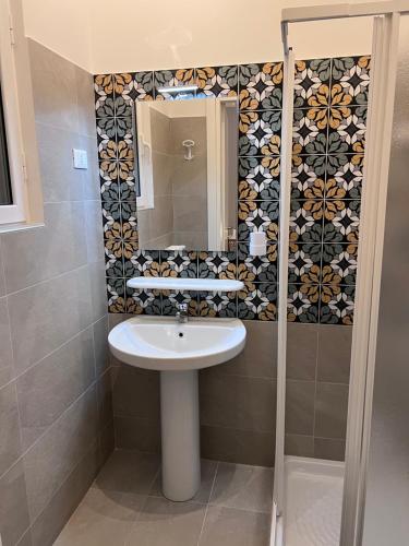 ein Bad mit einem Waschbecken und einem Spiegel in der Unterkunft Residenze Unità d'Italia in Bari