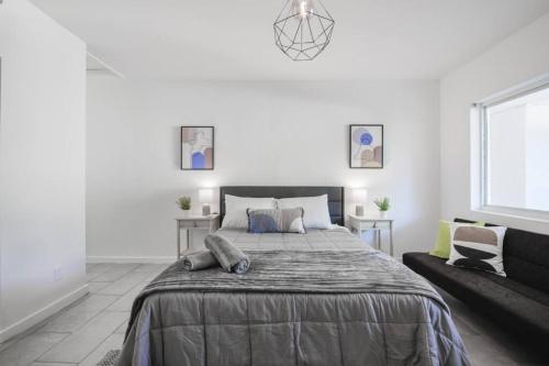 a white bedroom with a large bed and a couch at Great Studio Residence 15 min from the beach in Miami