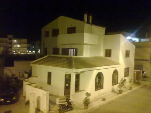 a large white building with a tower at night at B&B Pacheco in Paceco