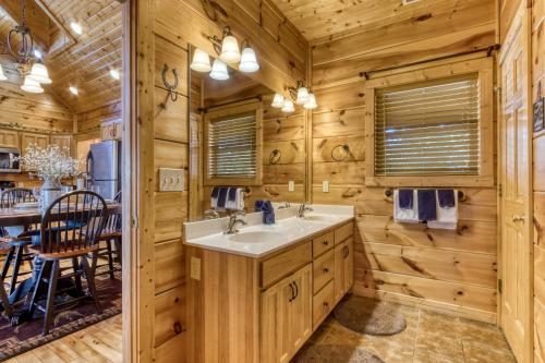 uma casa de banho com um lavatório e uma sala de jantar em Whiskey's mountain lodge em Sevierville