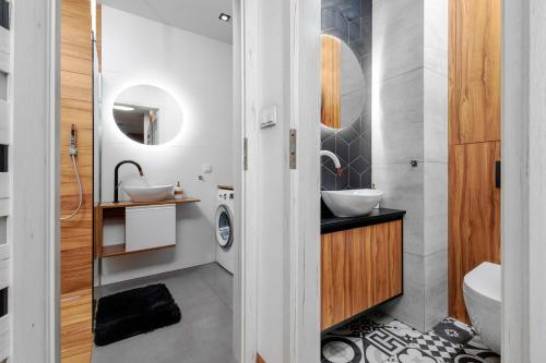 a bathroom with two sinks and a washing machine at Apartament Glamour Kraków in Krakow