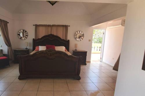a bedroom with a large bed with two tables and mirrors at Villa Del Carmen Family Vacation Home in Isabela