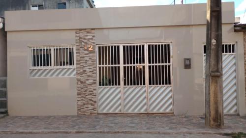 a white garage with two doors and a pole at Seu lar em Bonito-PE in Bonito