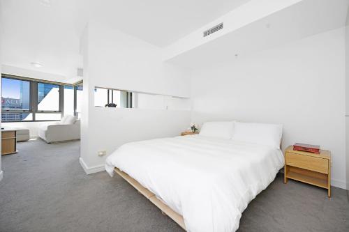 雪梨的住宿－The Alexander Apartments - Harbour Views, Parking, Pool, 24hr Concierge，白色卧室配有床和沙发