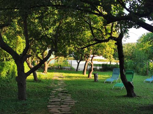 a park with two chairs and trees and a path at Vila Breza in Soko Banja