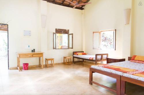 a room with two beds and a desk in it at Dudhsagar Plantation in Cormonem