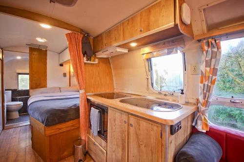a kitchen with a sink and a bed in a van at The Airstream in Penryn