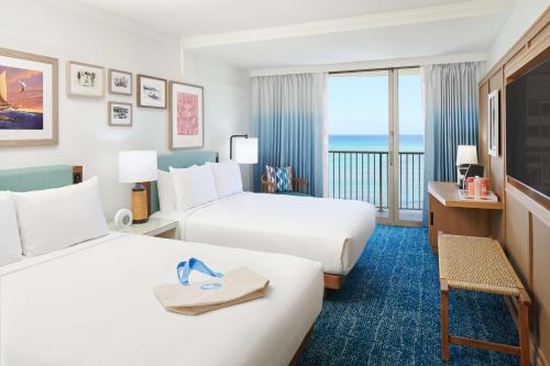 a hotel room with two beds and a view of the ocean at OUTRIGGER Reef Waikiki Beach Resort in Honolulu