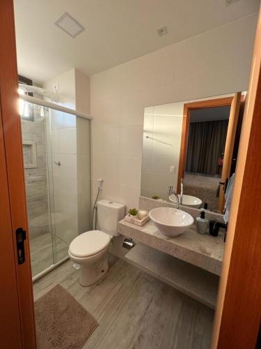 a bathroom with a toilet and a sink and a shower at Cantinho Vista Mar in Itacimirim