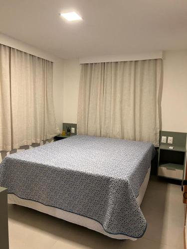 a bedroom with a large bed in front of curtains at Cantinho Vista Mar in Itacimirim