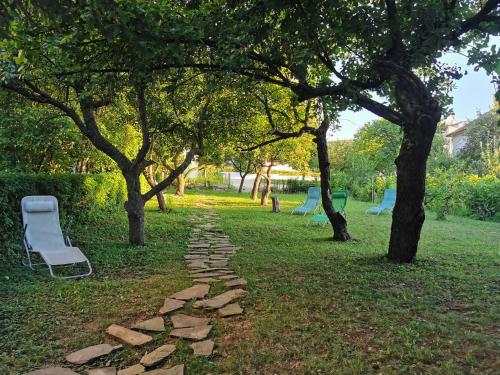 a stone path in a park with chairs and trees at Vila Breza in Soko Banja